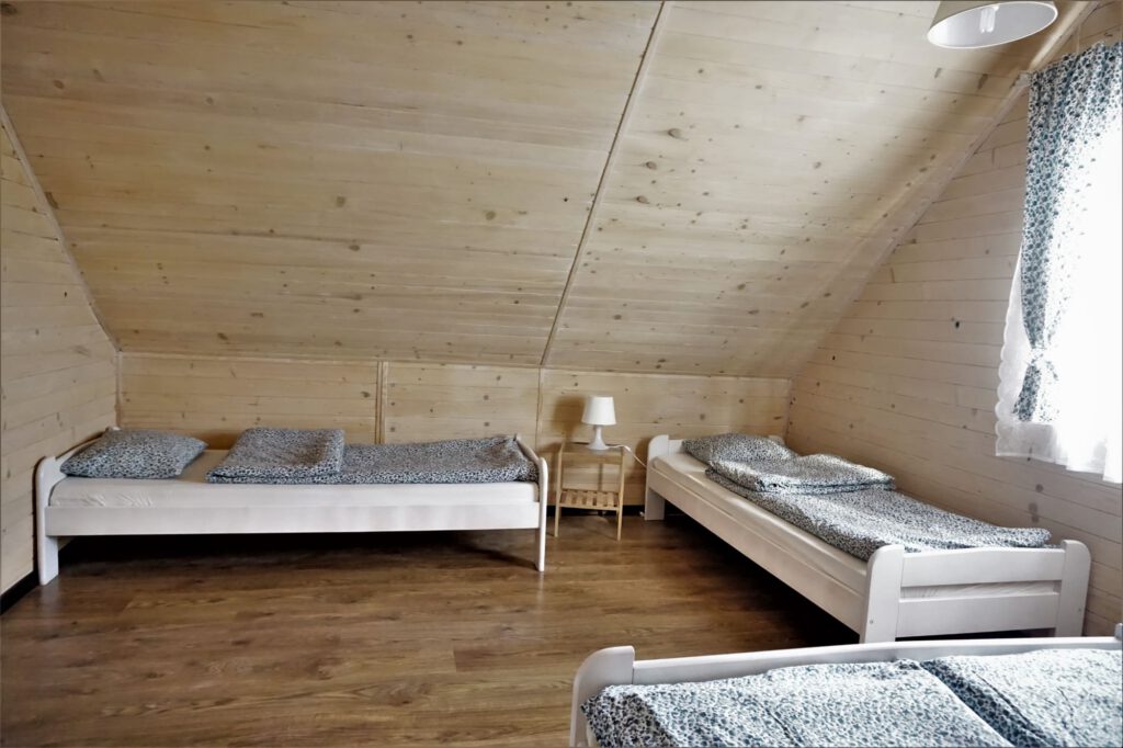 Zdjęcie przedstawiające sypialnie na piętrze domku 8-osobowego w domkach Balos w Karwii.